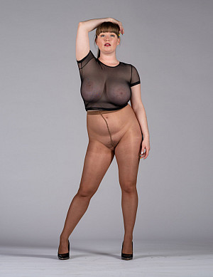 Fat woman with huge tits under a sheer blouse poses in pantyhose for a photo session