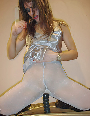 Slut Eve has ripped open the crotch of her white shiny pantyhose to masturbate with a large sex toy