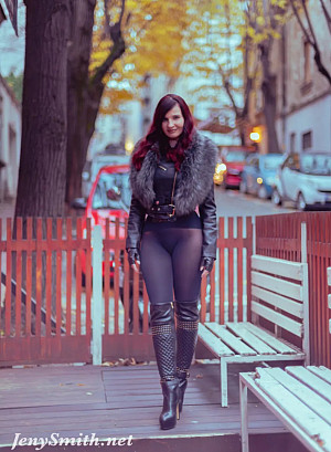 Jeny poses on a city street wearing just a stylish jacket, black seamless pantyhose and tall boots, her feminine curves and private areas fully on display
